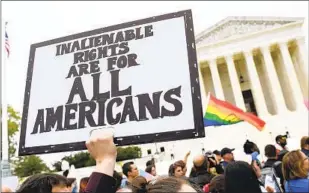  ?? SUSAN WALSH AP ?? Protesters gather outside the Supreme Court in 2019 as an LGBTQ rights case was being heard. President-elect Joe Biden is promising to carry out proposals to help the LGBTQ community.