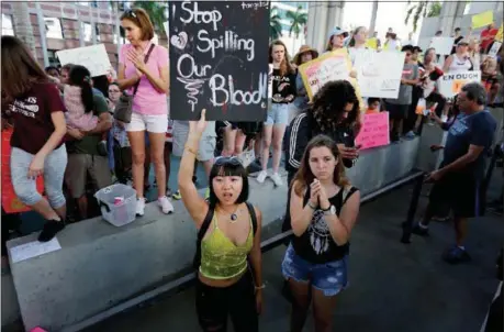  ?? BRYNN ANDERSON — THE ASSOCIATED PRESS ?? Marylene Dinliana, 18, holds a sign that reads, “Stop Spilling Our Blood” during a protest Saturday against guns on the steps of the Broward County Federal courthouse in Fort Lauderdale, Fla., after 17people were fatally shot earlier in the week at...