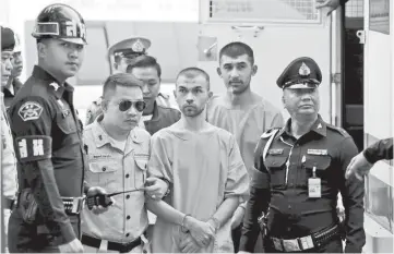  ??  ?? Suspects of last year’s Bangkok blast Bilal Mohammed (centre) (also known as Adem Karadag) andYusufu Mieraili are escorted by prison officers as they arrive at the military court in Bangkok,Thailand. — Reuters photo