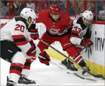  ?? KARL B DEBLAKER — THE ASSOCIATED PRESS ?? Carolina Hurricanes’ Jaccob Slavin (74) battles between New Jersey Devils’ Blake Coleman (20) and Brett Seney (43) during the first period.