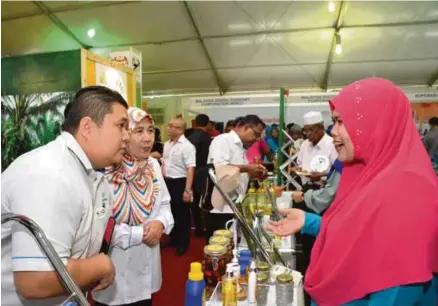  ??  ?? Pengunjung di ruang pameran MPOB diberi penerangan mengenai khasiat minyak sawit.