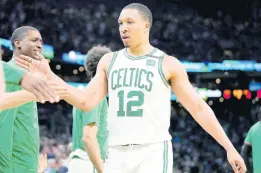  ?? AP ?? Boston Celtics forward Grant Williams (12) celebrates with teammates while approachin­g the bench during the second half of Game 7 of a NBA basketball Eastern Conference semi-finals playoff series in Boston yesterday. The Celtics won 109-81.