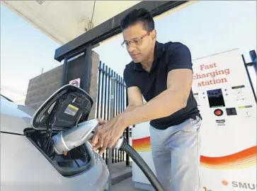  ?? Rich Pedroncell­i Associated Press ?? NEARLY 14,000 electric vehicles, or EVs, were bought in California in the first three months of the year. Above, Darshan Brahmbhatt plugs a charger into his electric vehicle at a charging station in Sacramento.