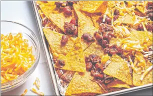  ?? SCOTT SUCHMAN/WASHINGTON POST/FOOD STYLING BY LISA CHERKASKY /THE WASHINGTON POST ?? My ideal platter of Loaded Nachos starts on a sheet pan. I line it with foil, to make cleanup easier.