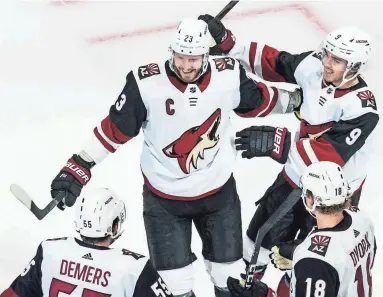 ?? PHOTOS BY JASON FRANSON/THE CANADIAN PRESS VIA AP ?? Coyotes’ Oliver Ekman-Larsson (23), Clayton Keller (9), Jason Demers (55) and Christian Dvorak (18) celebrate a goal against the Predators during the qualifying round game Sunday.