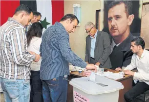  ?? SANA THE ASSOCIATED PRESS ?? Syrians cast their votes at a polling station in Damascus on Sunday.