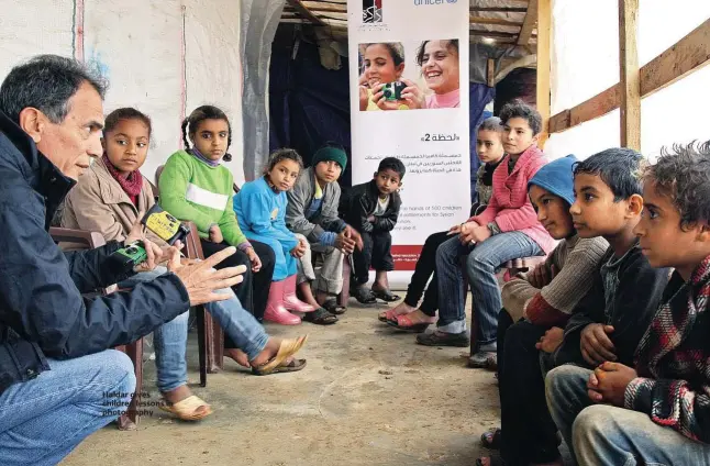  ??  ?? Haidar gives children lessons in photograph­y