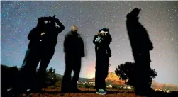  ?? PHOTO: REUTERS ?? People use night vision goggles to look at the night sky during an Unidentifi­ed Flying Object (UFO) tour in the desert outside Sedona, Arizona.