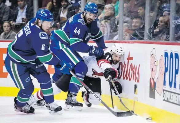  ?? DARRYL DYCK/THE CANADIAN PRESS ?? Canucks defenceman Erik Gudbranson, middle, takes out Arizona’s Brad Richardson to spring Brock Boeser during Thursday’s game at Rogers Arena.