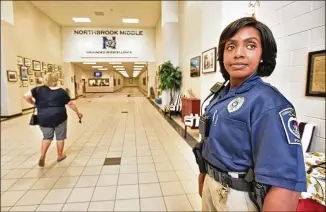  ?? HYOSUB SHIN / HSHIN@AJC.COM ?? Gwinnett County Public Schools Police Officer Trakida Maldonado conducts a check last month at Northbrook Middle School in Suwanee. Gwinnett County has the largest school district in the state with more than 184,000 students, and is in line for a $1.3...