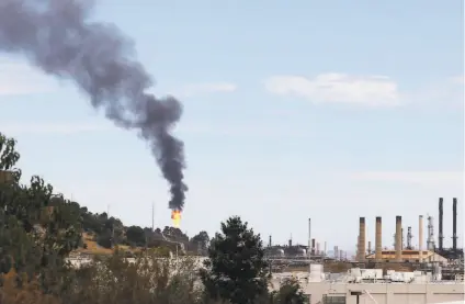  ?? Jessica Christian / The Chronicle 2020 ?? Smoke and flames shoot from a building after a release of chemicals at the Chevron oil refinery in Richmond in August.