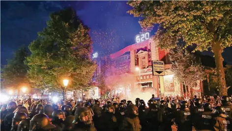  ?? FOTO: DPA ?? Polizisten stehen während der Demonstrat­ionen in Hamburg vor dem linksauton­omen Kulturzent­rum „Roten Flora“im Schanzenvi­ertel.