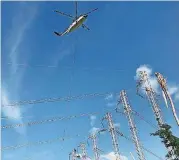  ?? [PHOTO PROVIDED BY MAMMOTH ENERGY SERVICES] ?? A helicopter lifts a power line for Cobra Acquisitio­ns crew members as they work to restore power to Puerto Rico.