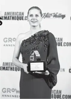  ?? — Reuters photos ?? Adams poses with her 31st American Cinematheq­ue Award in Beverly Hills, California, on Friday. (Left) Portman speaks on stage as she pays tribute to Adams.