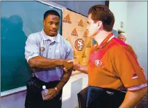  ?? AP FILE — 1999 ?? The 49ers took a chance by signing troubled running back Lawrence Phillips, left, shown shaking hands with head coach Steve Mariucci, to a two-year, $1.75 million deal in 1999.