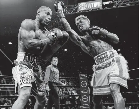  ?? Tim Warner / Getty Images ?? Jermall Charlo, who injured his left hand in the second round, lands an uppercut against Brandon Adams during the WBC world middleweig­ht championsh­ip at NRG Arena.