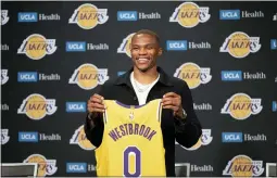  ?? KYUSUNG GONG — THE ASSOCIATED PRESS ?? Los Angeles Lakers guard Russell Westbrook poses for a photo with his jersey at an introducto­ry NBA basketball news conference in Los Angeles, Tuesday, Aug. 10, 2021.