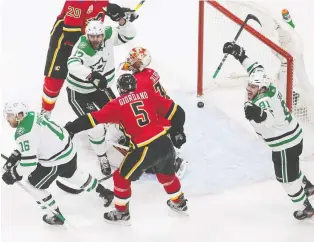  ?? JASON FRANSON/THE CANADIAN PRESS ?? The Flames’ Cam Talbot and Mark Giordano react as Joe Pavelski, Alexander Radulov and Tyler Seguin of the Stars celebrate a goal during playoff action in Edmonton on Sunday.