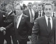  ?? AP/LIONEL BONAVENTUR­E ?? Outgoing French President Nicolas Sarkozy (right) walks with President-elect Francois Hollande to take part Tuesday in a Paris ceremony marking the end of World War II in Europe.