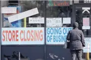  ?? NAM Y. HUH/ASSOCIATED PRESS ?? A woman looks at signs at a store closed due to COVID-19 earlier this month in Niles, Illinois. The geography of infections is affecting political debate, observers say.