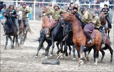  ?? AFP ?? Horsemen from the Kandahar team (in black) and the Kunduz team compete during the final of Afghanista­n’s Buzkashi League in Kabul on Sunday.