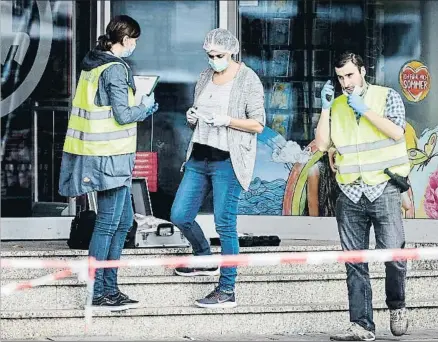  ?? MARKUS SCHOLZ / AP ?? La policía científica recoge pruebas a la puerta del supermerca­do