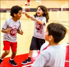  ?? VINCENT OSUNA PHOTO ?? Thomas Nixon, 7, (left) celebrates with a fellow camp goer after he successful­ly made a shot during the 2018 Imperial Valley College basketball camp on Thursday at the DePaoli Sports Complex in Imperial.
