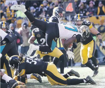  ?? ROB CARR/GETTY IMAGES ?? Jacksonvil­le Jaguars running back Leonard Fournette dives over the Pittsburgh Steelers defence into the end zone for a touchdown Sunday in Pittsburgh. Fournette rushed for 109 yards and three TDs in Jacksonvil­le’s 45-42 upset win over the Steelers.