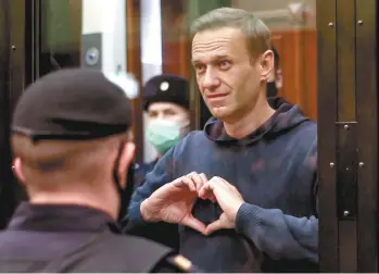  ?? ALEXEY PAVLOVSKY AGENCE FRANCE-PRESSE ?? L’opposant russe Alexeï Navalny, 44 ans, a écouté le jugement, mardi, dans la cage de verre réservée aux prévenus au tribunal de Moscou. Il a adressé des signes de coeur à son épouse, Ioulia.