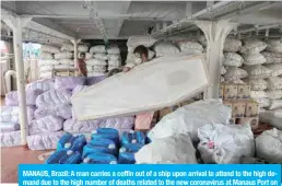  ?? — AFP ?? MANAUS, Brazil: A man carries a coffin out of a ship upon arrival to attend to the high demand due to the high number of deaths related to the new coronaviru­s at Manaus Port on May 8, 2020.