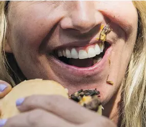  ??  ?? A cricket is stuck to a woman’s mouth after she took a bite of Gourmet Burger’s Cricket Burger during the PNE fair Sunday.