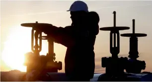  ?? — Reuters ?? A worker checks the valve of an oil pipe at a oilfield near Kogalym, Russia.