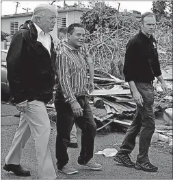  ??  ?? President Donald Trump, joined by FEMA Administra­tor Brock Long, right, and others, tours an area affected by Hurricane Maria in Guaynabo, Puerto Rico. Trump visited Puerto Rico on Tuesday.