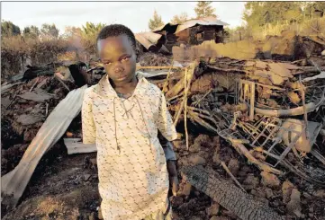  ??  ?? MORE OF THE SAME? A survivor, 11, stands amid the ruins of the Kenyan Assemblies of God Pentacosta­l Church where 18 people were burnt alive during ethnic clashes after elections in 2008.