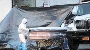  ??  ?? BRENDAN MCDERMID/REUTERS Workers roll a coffin down a city street outside the Andrew T. Cleckley Funeral Services funeral home, which was found to be storing dead bodies in unrefriger­ated U-haul vehicles during the COVID-19 outbreak in the Brooklyn borough of New York City, US.