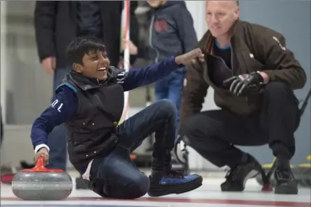  ?? FRANK GUNN, THE CANADIAN PRESS ?? Arun Daniel, 11, from Sri Lanka, takes a tumble while getting instructio­n from club member Bruce Goody during a refugee curling day Wednesday at the Royal Canadian Curling Club in Toronto.