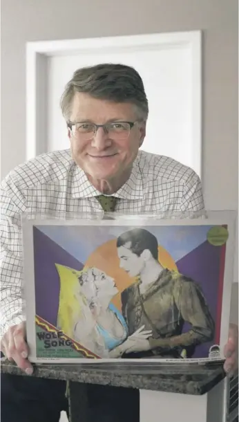  ?? CHARLES REX ARBOGAST/AP ?? Dwight Cleveland holds a lobby card for the 1929 silent film “Wolf Song,” directed by Victor Fleming and starring Gary Cooper and Lupe Vélez. Production of lobby cards ended in the late 1970s and early 1980s, though one director brought them back in 2015.