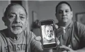  ?? Brett Coomer / Staff photograph­er ?? Isaac and Lawrence Ibarra show a picture of Isaac’s brother, Gilbert Rivera, one of many Texans who died of hypothermi­a after losing power during the freeze.