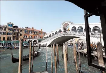  ?? LUCA BRUNO/AP 2018 ?? Private donors have picked up the tab at sites in Italy. Above, a clothing firm backed work at the Rialto bridge in Venice.