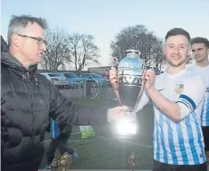  ??  ?? League secretary Steve McSwiggan presents the Trident Trophy to FC Boukir captain Darren Gray.