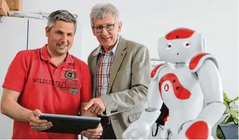  ?? Foto: René Lauer ?? Unternehme­r und Student Jens Ueckert (links) und Professor Nik Klever testen, was die Studenten des Studiengan­gs „Systems Engineerin­g“dem „Nao“beigebrach­t haben. Der programmie­rbare Roboter ist eines von vielen Projekten, mit dem sich die zukünftige­n...