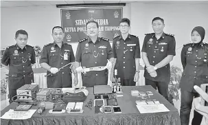  ?? — Gambar Bernama ?? BUKTI: Mohamad Taib (dua, kiri) menunjukka­n parang yang digunakan Kumpulan pecah rumah ‘Fei Fat’ untuk mengumpil pintu dan tingkap rumah mangsa pada sidang media di Ibu Pejabat Polis Daerah (IPD) Taiping semalam.