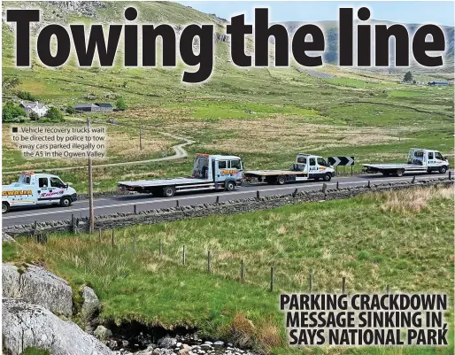  ?? ?? Vehicle recovery trucks wait to be directed by police to tow away cars parked illegally on the A5 in the Ogwen Valley