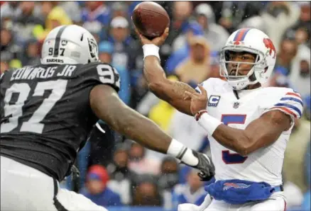  ?? AP PHOTO/ADRIAN KRAUS ?? Buffalo Bills quarterbac­k Tyrod Taylor (5) throws a pass as Oakland Raiders defensive end Mario Edwards (97) rushes in during the first half of an NFL football game, Sunday, Oct. 29, 2017, in Orchard Park, N.J.