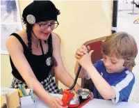  ??  ?? A youngster tries his hand at badge making