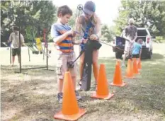  ?? STAFF FILE PHOTO BY ERIN O. SMITH ?? Brian Szakacs, 6, gets help from Madison Bowers, a recreation specialist with Outdoor Chattanoog­a, during a previous Family Fun Day at Greenway Farm. The next free Family Fun Day is Sunday, Aug. 18.