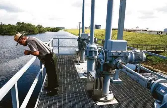  ?? Michael Ciaglo / Houston Chronicle ?? Park Ranger David Mackintosh surveys the water level earlier this year from the structure at Barker reservoir that controls the rate of water being released downstream.