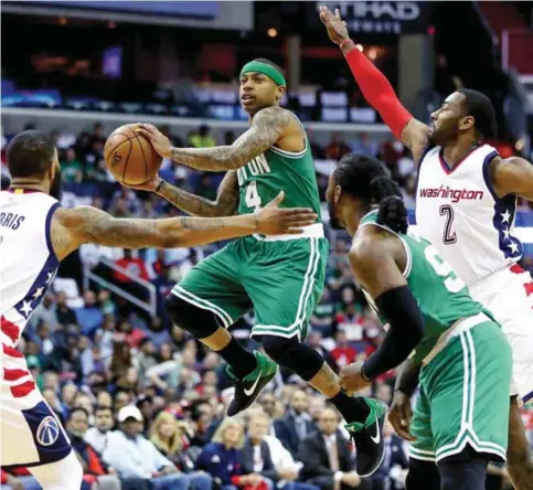  ?? — AP ?? WASHINGTON: Boston Celtics guard Isaiah Thomas (4), center, passes between Washington Wizards forward Markieff Morris (5) and guard John Wall (2) during the first half of a second-round NBA playoff series.