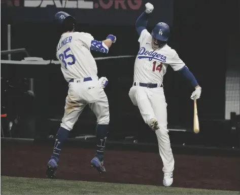  ?? ASSOCIATED PRESS ?? LOS ANGELES DODGERS’ CODY BELLINGER CELEBRATES his home run with Enrique Hernandez against the Atlanta Braves during the seventh inning in Game 7 of the National League Championsh­ip Series on Sunday in Arlington, Texas.