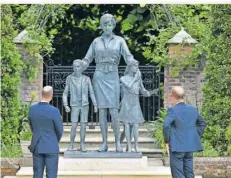  ?? FOTO: AP ?? William und Harry betrachten die Statue ihrer Mutter Diana, die von Kindern umgeben dargestell­t ist, auf dem Gelände des Kensington-Palasts.